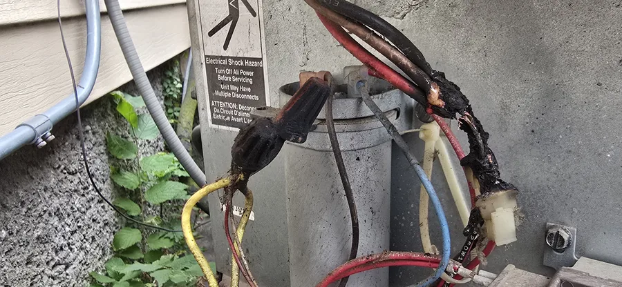 Burned and melted outdoor AC disconnect wiring from a storm-related electrical failure