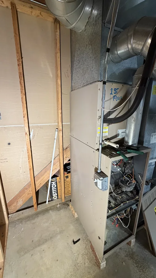 Calefacción y manejador de aire instalados en un clóset mecánico enmarcado, con la tarjeta de control abierta